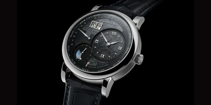 Montre de luxe avec cadran complexe et bracelet en cuir noir.