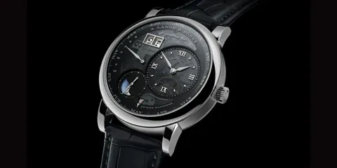 Montre de luxe avec cadran complexe et bracelet en cuir noir.