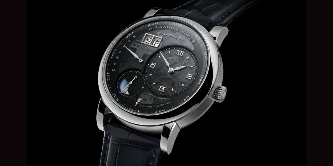 Montre de luxe avec cadran complexe et bracelet en cuir noir.