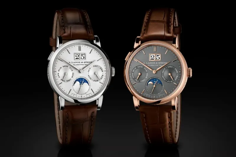 Deux montres de luxe avec affichage de phase lunaire et bracelet en cuir marron.