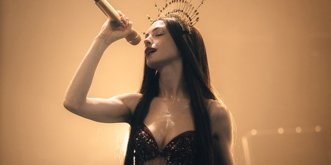 Femme chantant avec un micro et une couronne, éclairage doré.