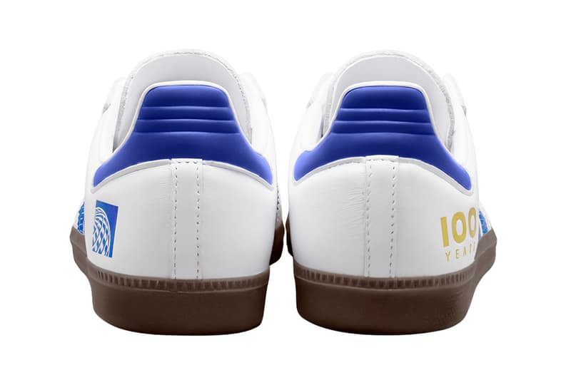 Dos de baskets blanches avec accents bleus, texte or '100'.