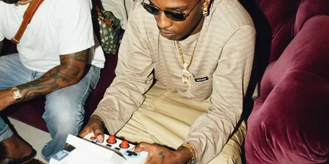 Homme jouant avec une manette de jeu sur un canapé.