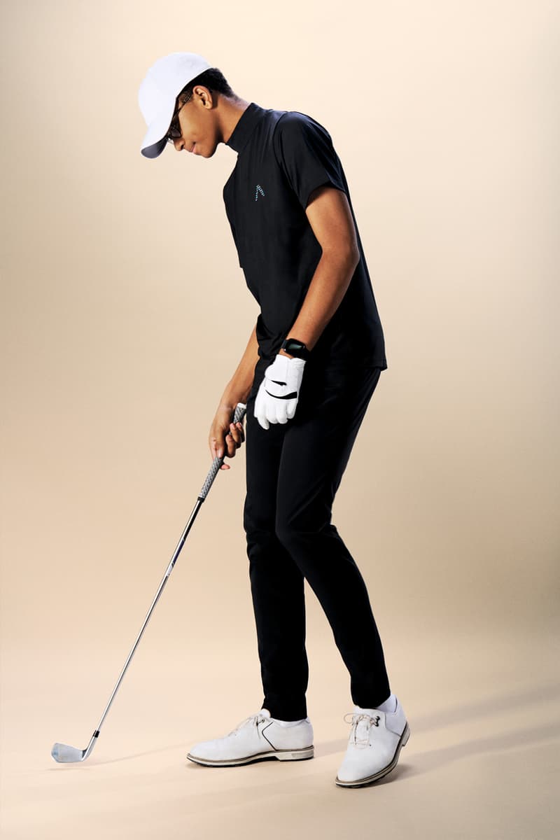 Homme jouant au golf en tenue noire, vue de profil, fond beige.