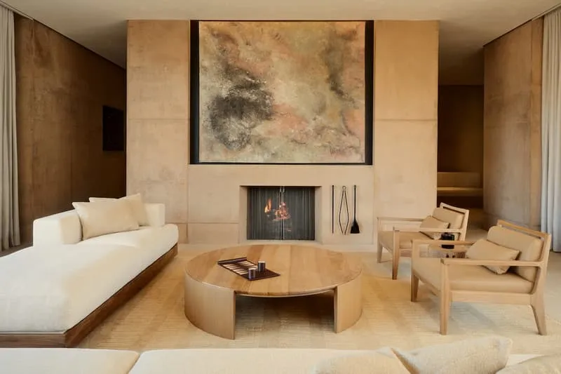 Salon moderne avec cheminée et tableau abstrait au-dessus.