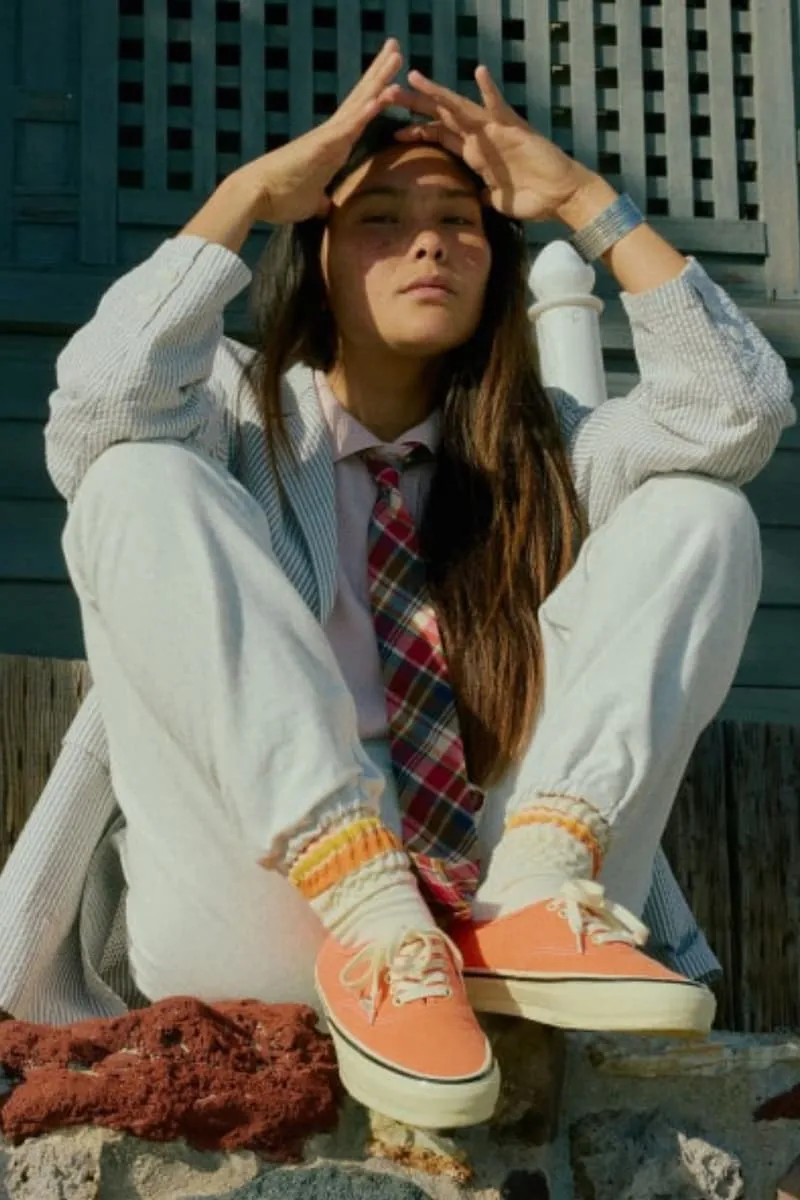 Personne assise en costume décontracté avec des chaussures orange.