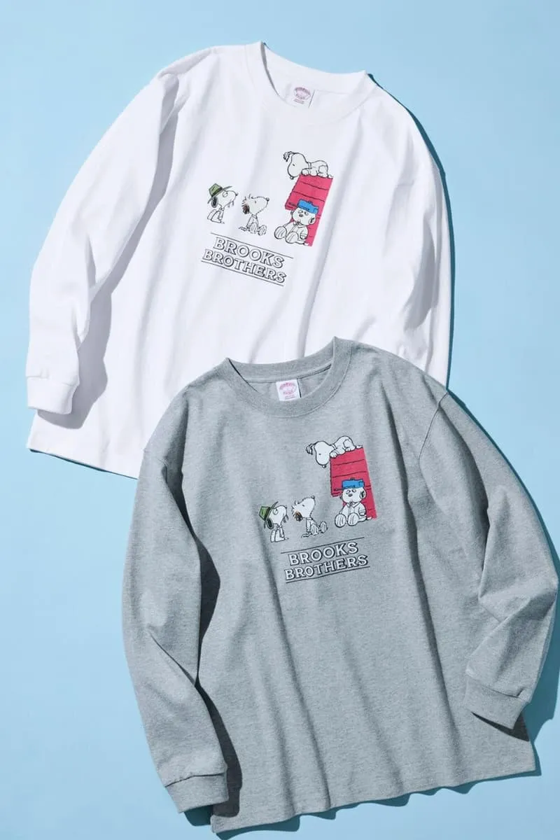 Deux pulls Snoopy blanc et gris sur fond bleu.