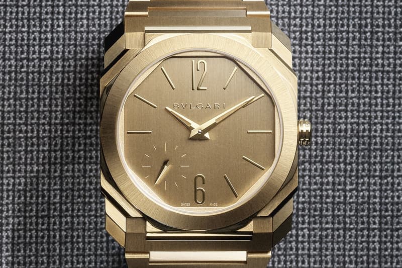 Montre en or Bulgari sur fond texturé gris.