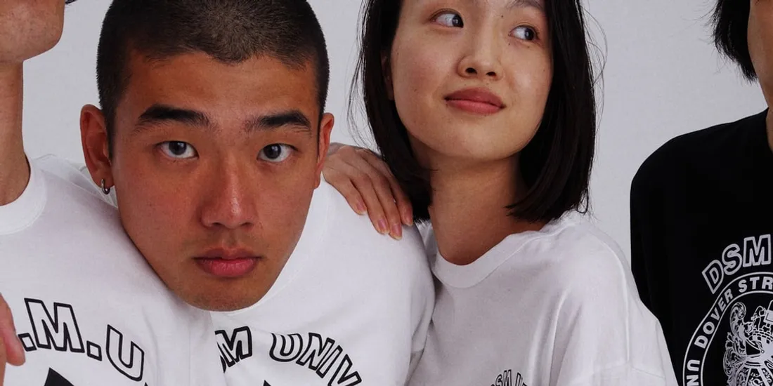 Deux personnes en t-shirts blancs et noirs regardent vers la caméra.