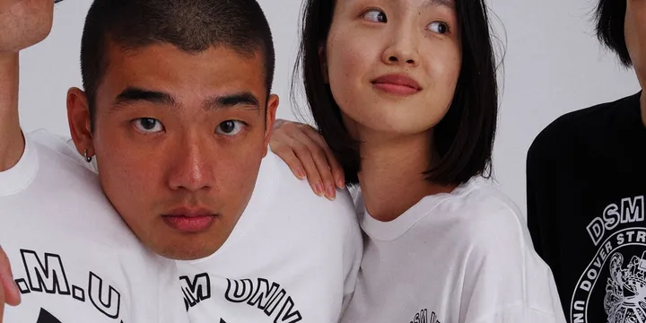 Deux personnes en t-shirts blancs et noirs regardent vers la caméra.
