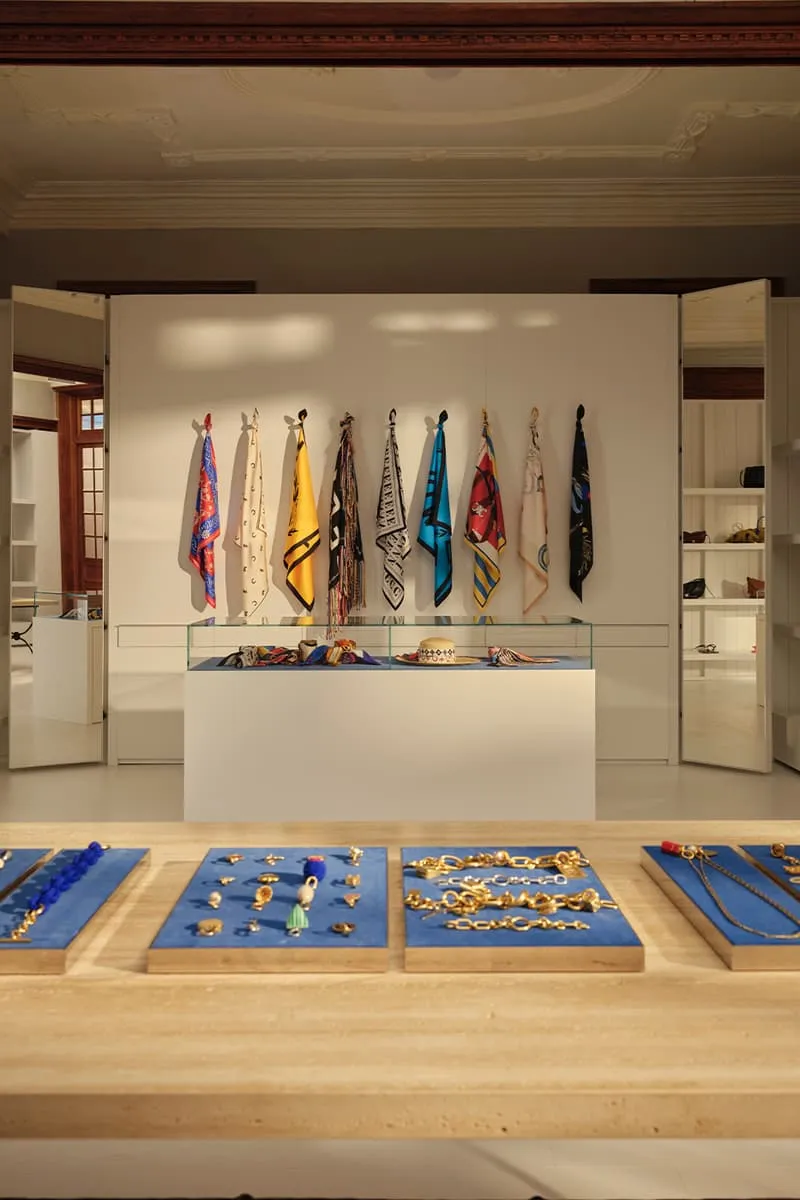 Intérieur avec foulards colorés et bijoux sur présentoirs.