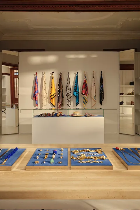 Boutique avec foulards colorés et bijoux dorés exposés.