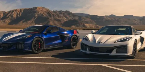 Deux voitures de sport devant des montagnes.