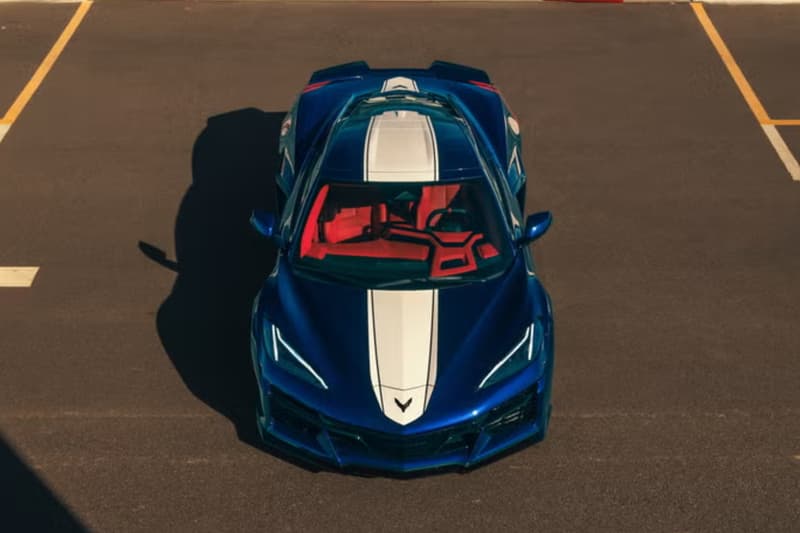 Voiture de sport bleue avec intérieur rouge, vue de dessus, sur un parking.