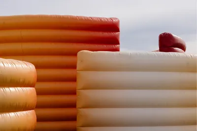 Structures gonflables rouges et oranges empilées les unes à côté des autres.