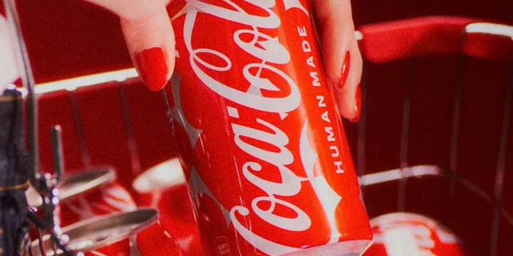 Canette rouge Coca-Cola avec texte 'Human Made' tenue par une main