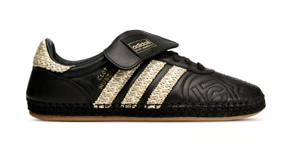 Chaussure noire avec motifs dorés et étiquette Adidas, design unique.