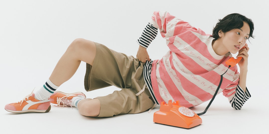 Personne posant avec un téléphone orange, tenue décontractée et colorée.