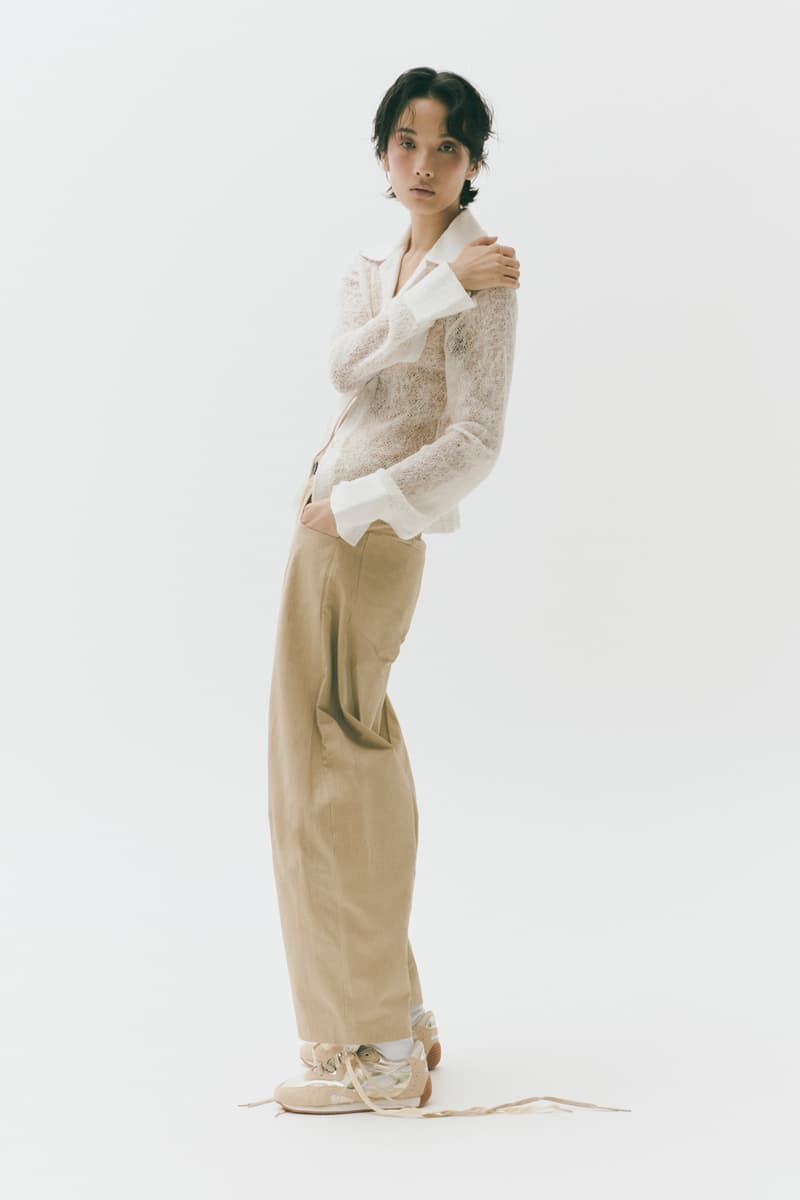 Femme en tenue décontractée, pull blanc et pantalon beige.