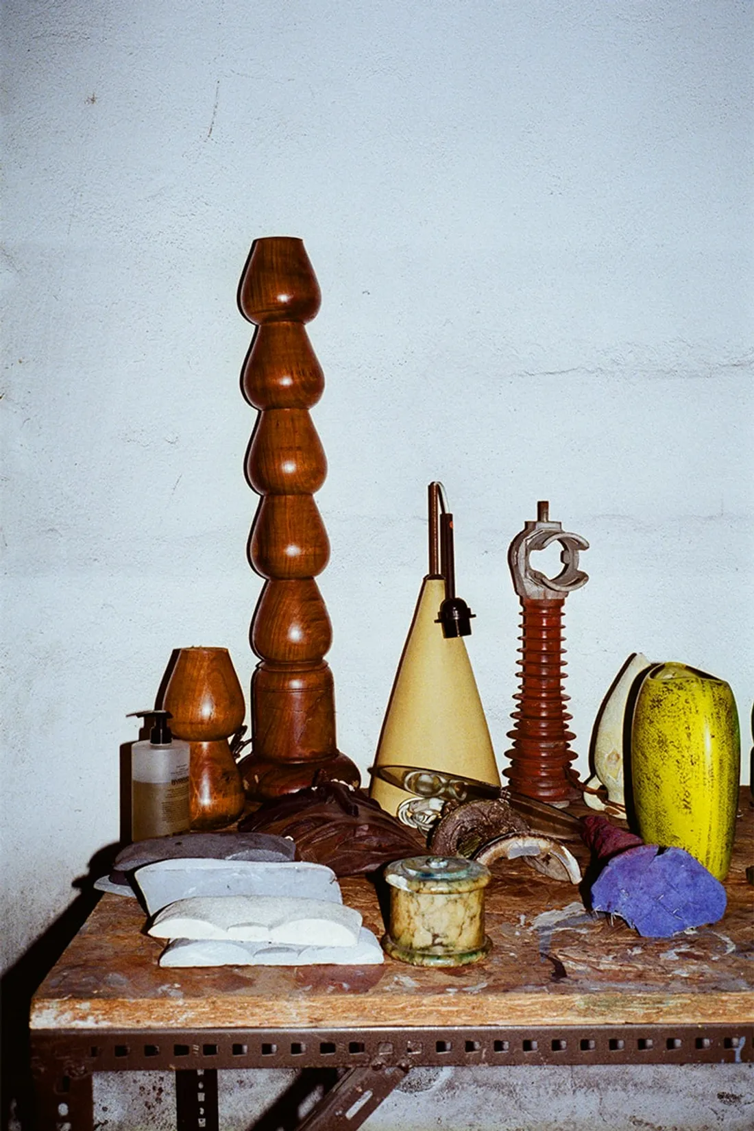 Objets variés sur une étagère, dont lampes et sculptures.