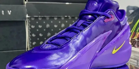 Chaussure de sport violette avec une marque jaune.