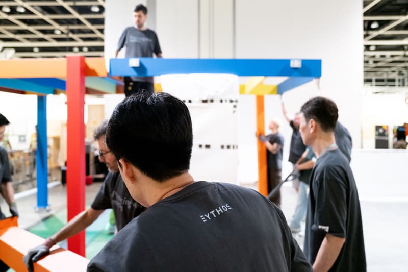 Personnes assemblant une structure multicolore à l'intérieur.