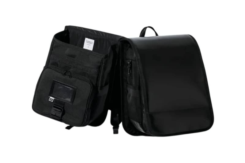 Sac à dos noir avec compartiments ouverts, style moderne et minimaliste.