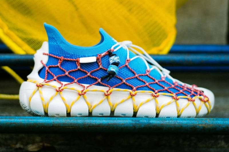 Chaussure bleue et blanche avec filet rouge et jaune, design unique et moderne.