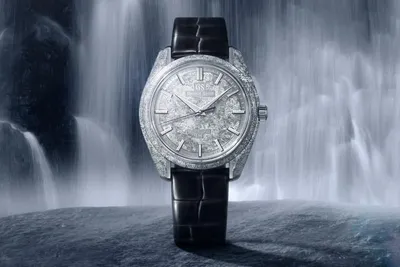 Montre avec cadran texturé, bracelet en cuir noir, fond de cascade