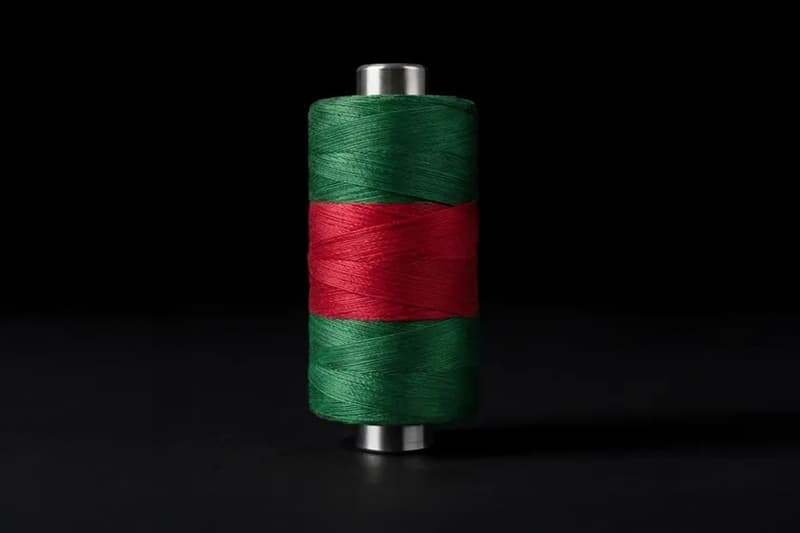 Bobine de fil avec bandes verte et rouge, fond noir