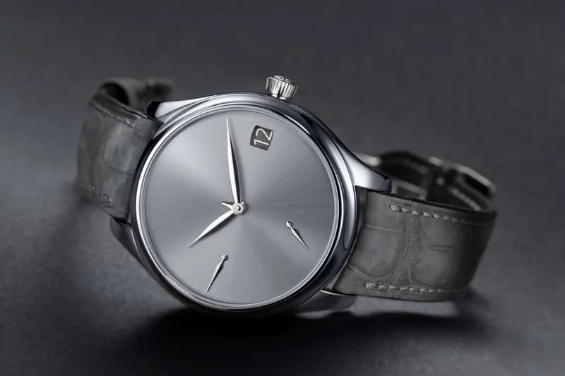 Montre élégante avec cadran gris et bracelet en cuir noir.