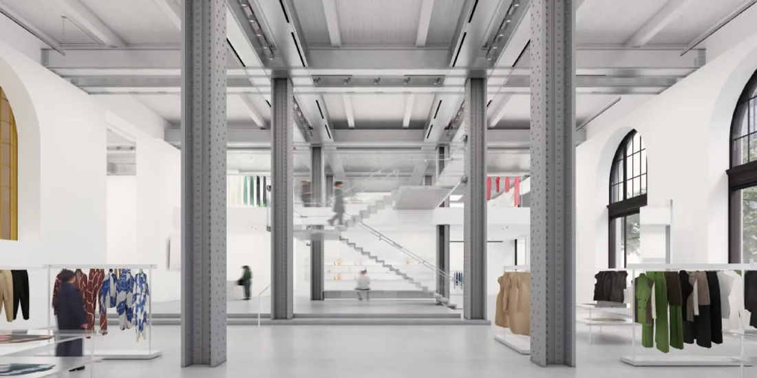 Intérieur moderne avec piliers, vêtements sur présentoirs.