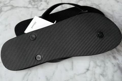 Sandale noire vue de dessous sur fond de marbre.