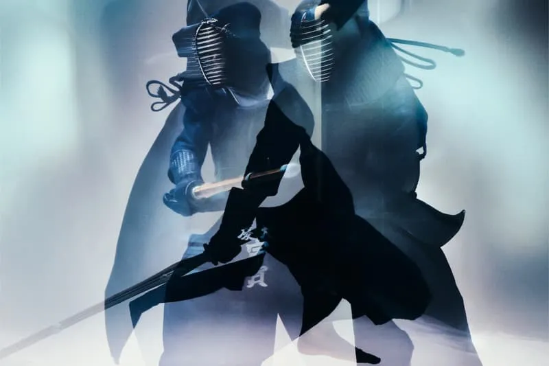 Deux personnes en tenue de kendo s'affrontent avec des bâtons.