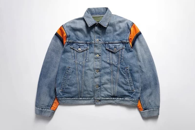 Veste en jean bleu avec détails orange sur les épaules.