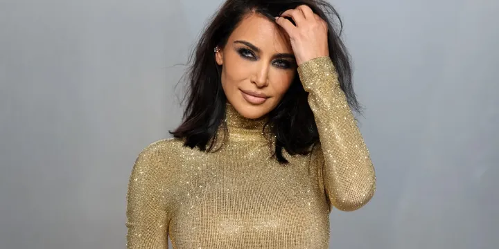 Femme en robe scintillante dorée, regard intense.