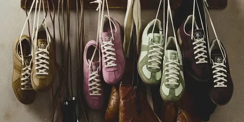 Chaussures colorées suspendues par leurs lacets contre un mur.