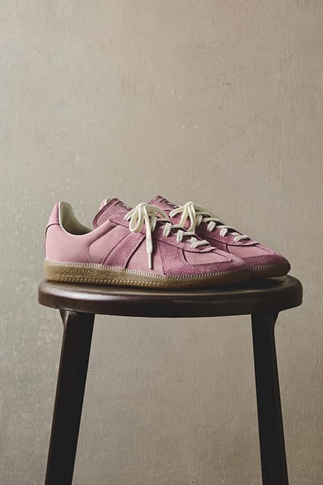 Chaussures roses sur un tabouret en bois.