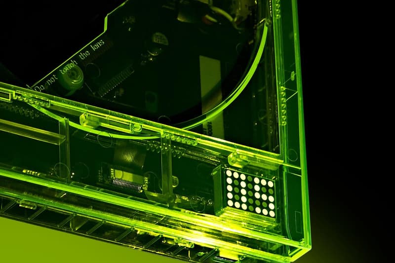Détail d'un boîtier électronique transparent vert avec composants visibles.