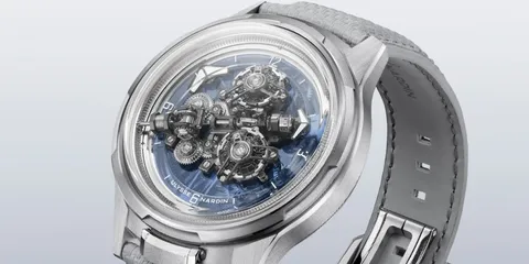 Montre argentée avec mécanisme visible et bracelet en cuir gris