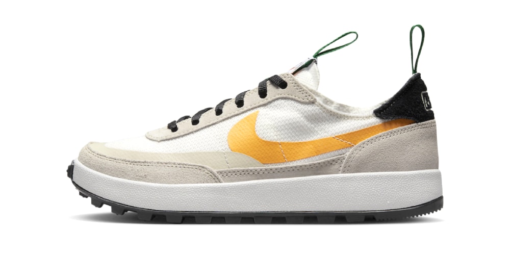 Chaussure au design moderne avec logo orange sur les côtés.