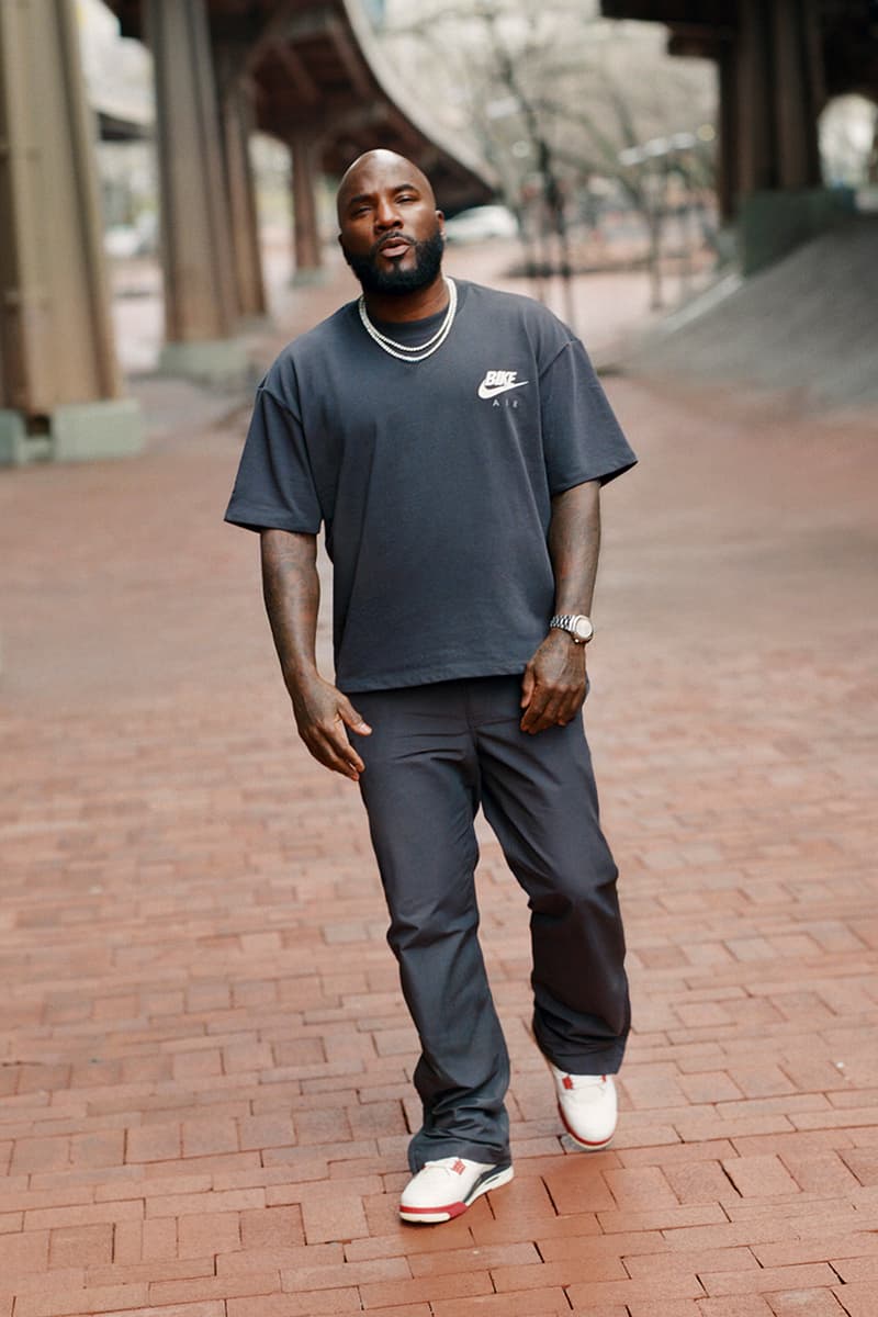 Un homme marche sur une allée en brique, portant un t-shirt et un pantalon sombres.