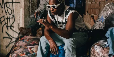 Personne assise avec lunettes de soleil dans un environnement urbain.