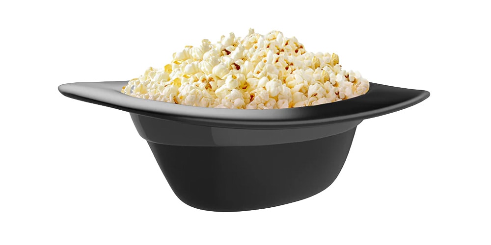 Un chapeau noir rempli de pop-corn blanc.