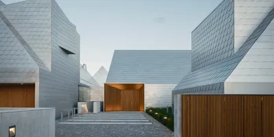 Architecture moderne avec toits en tuiles argentées et murs en bois.
