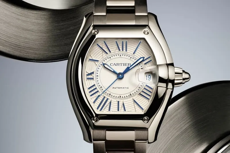 Montre Cartier avec bracelet métallique et chiffres romains bleus.