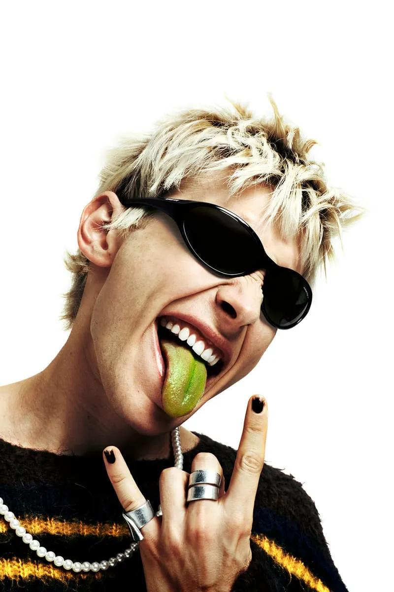 Personne avec lunettes de soleil et langue colorée, geste rock'n'roll.