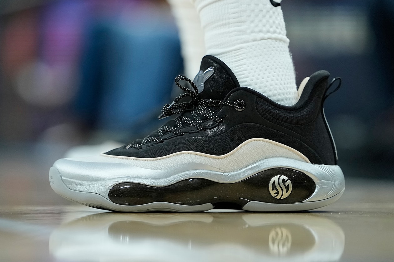 Chaussure de sport noire et blanche sur un terrain de basket.