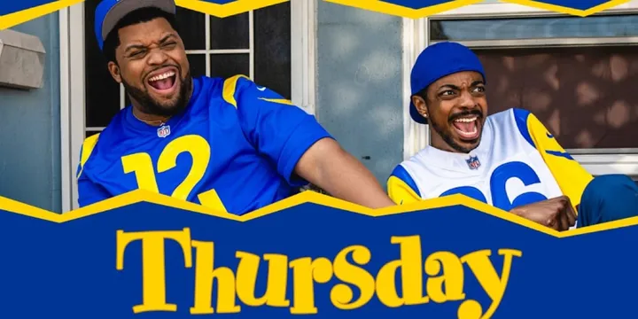 Deux hommes souriants portant des maillots de sport devant une maison.