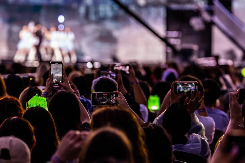 Foule utilisant des smartphones lors d'un concert en plein air.